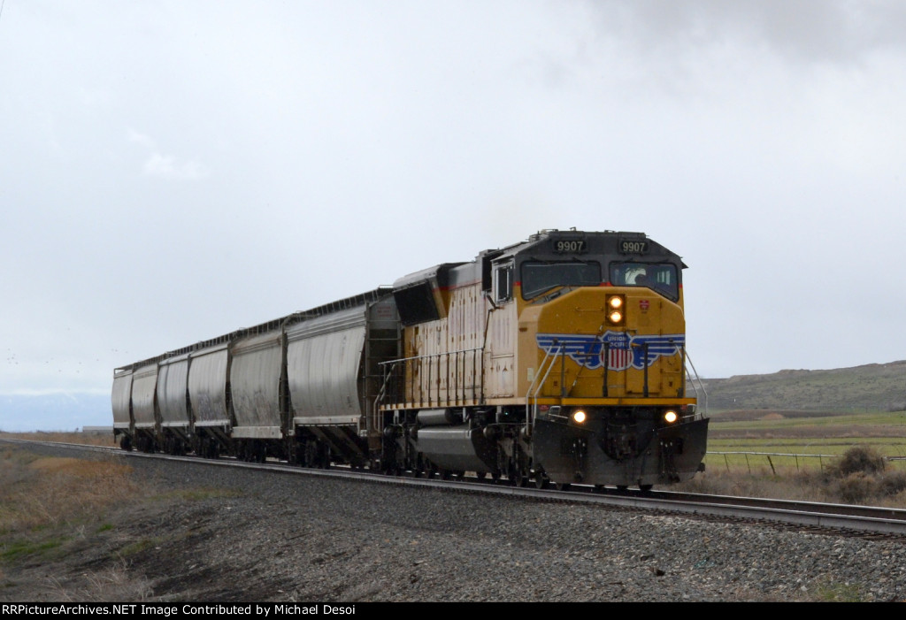 UP SD59MX #9907 leads the Cache Valley Local (LCG-41E) approaching the 4800 W. 900N. grade xing in Trenton, Utah. April 15, 2022